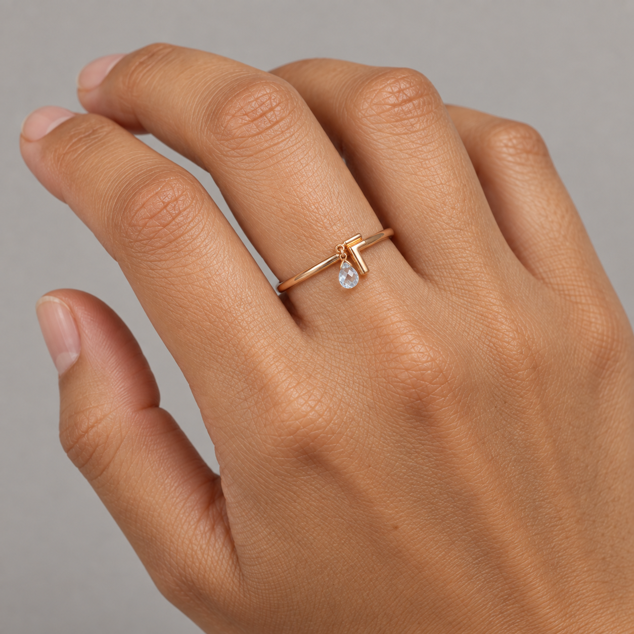 Model wearing the Lesunja Collection L Ring Rose Gold Light Blue Sapphire