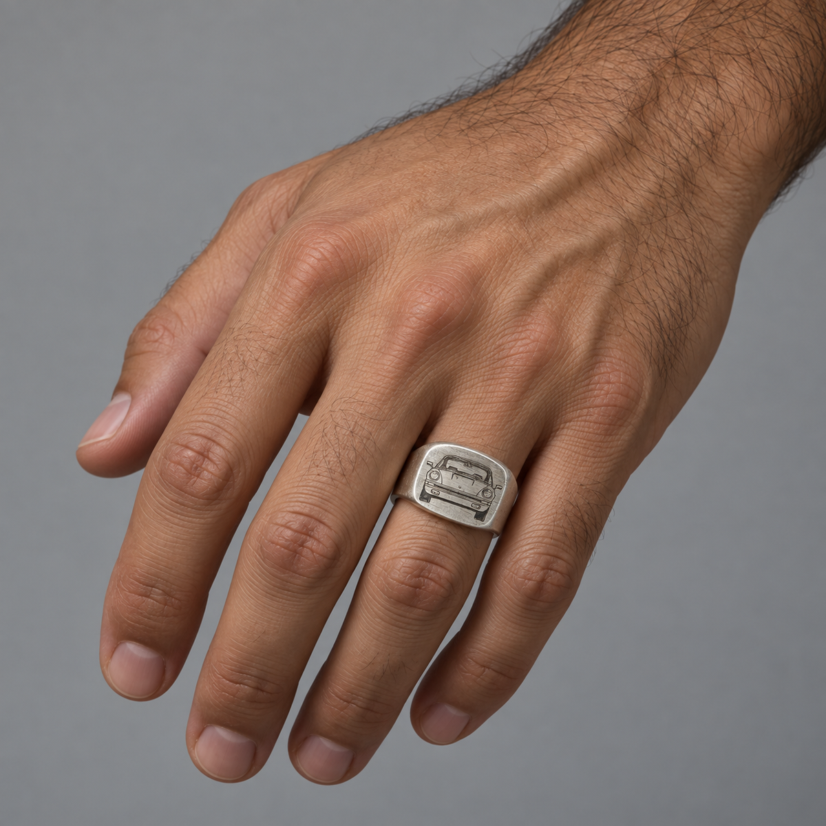 Model wearing the Lesunja signet ring in silver engraved with a Porsche